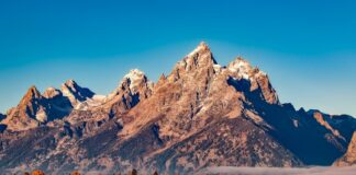 Breathtaking autumn landscape of Grand Teton with snow-capped peaks and colorful trees.