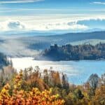 Stunning autumn scenery with sunlit lake and mountains, capturing nature's vibrant colors.